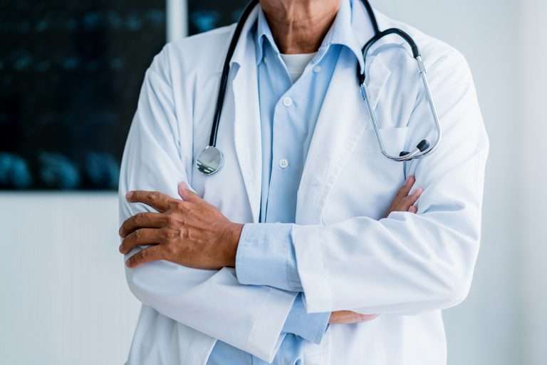 asian doctor standing with confident hospital background health