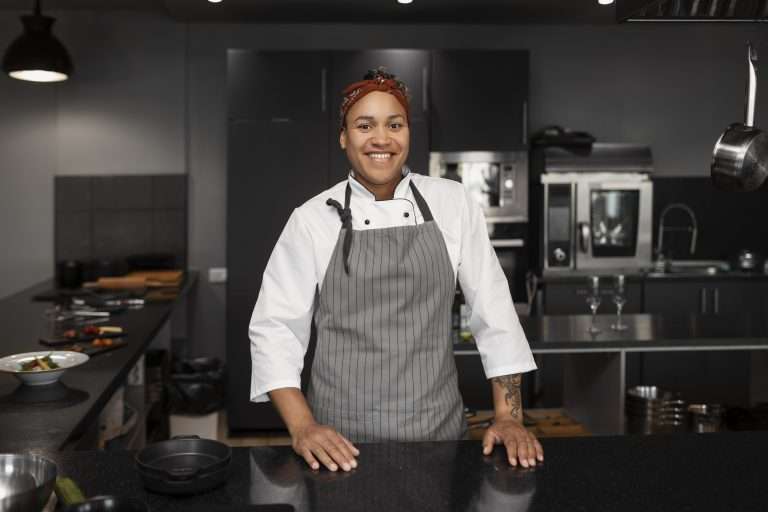 Mulher trabalhando em cozinha profissional.