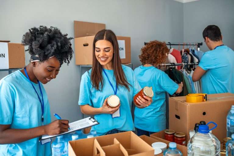 Voluntários organizam alimentos, roupas e itens essenciais em centro de doações, representando ações de investimento social privado voltadas ao fortalecimento de organizações sociais e ao apoio de comunidades em situação de vulnerabilidade.